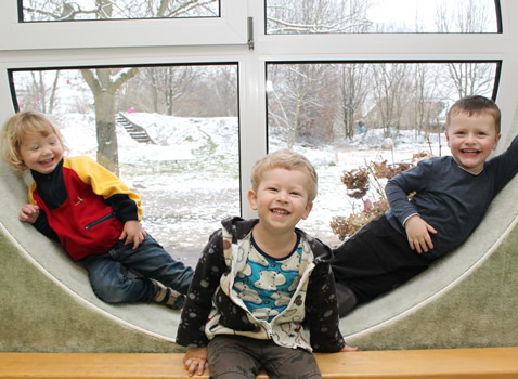 Kindergartenkinder im runden Fenster